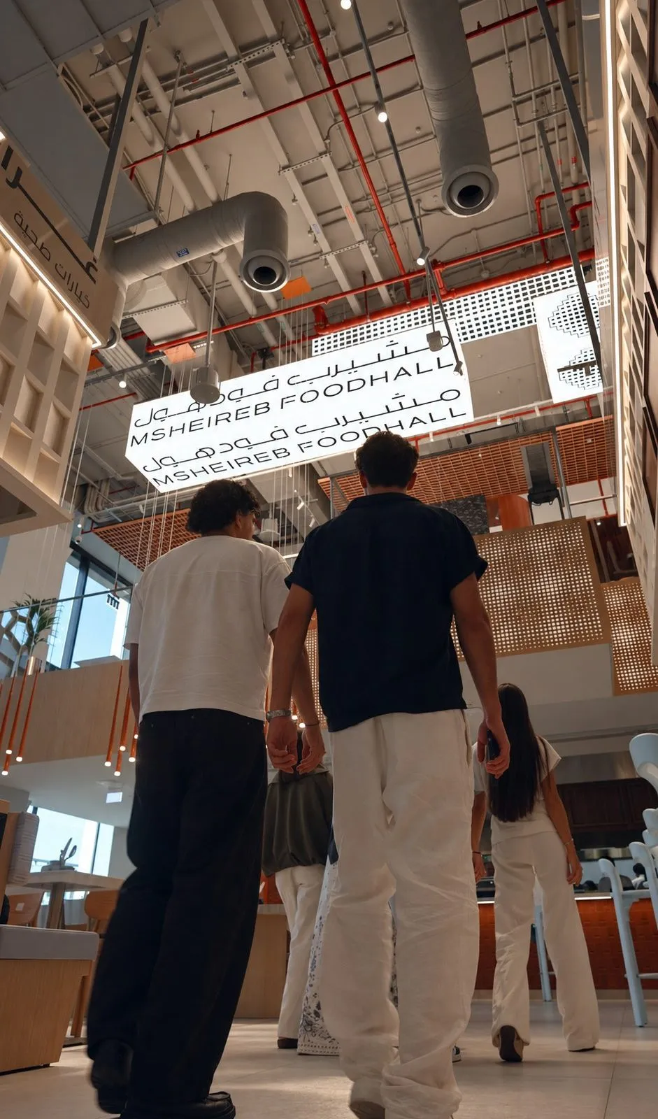 Two guests walking through the hall beneath the signage