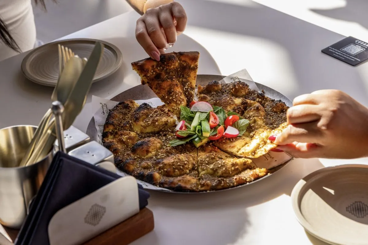 A flatbread being served at the table